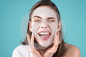 Woman facial mask with fun, face clay. Funny woman with cosmetic facial procedure, spa skin concept. Skin care beauty