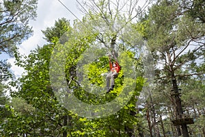 Woman facial mask jumping on a zip line in a pine forest