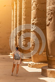 Woman facing the columns of an egyptian temple