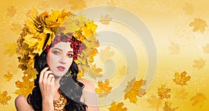 Woman-Fall. Beautiful woman in wreath of autumn leaves and guelder-rose on background of flying leaves.