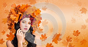 Woman-Fall. Beautiful woman in wreath of autumn leaves and guelder-rose on background of flying leaves.
