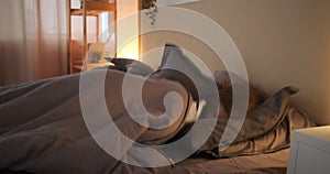 Woman falling asleep with quilt on bed