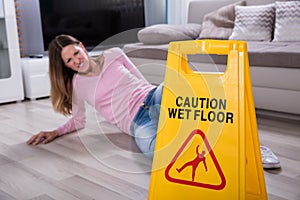 Woman Falling Near Caution Sign At Home