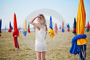 Woman with famous colorful parasols on Deauville Beach in France