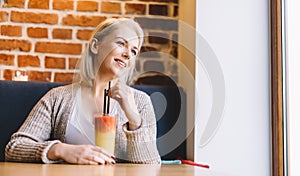 Woman with fancy cocktail looking through the window.