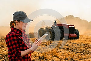 Woman farmer controls an autonomous tractor