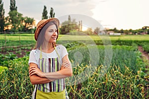 Woman farmer looking at vegetables on kitchen-garden in countryside. Agriculture and farming concept