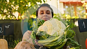 Woman farmer presenting cauliflower for healthy nutrition