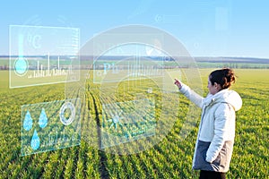 A woman farmer selects on a virtual screen the parameters that control the growth of the crop and analyzes the data using artifici