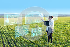 A woman farmer selects on a virtual screen the parameters that control the growth of the crop and analyzes the data using artifici photo