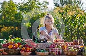 A woman farmer sells fruits and vegetables at a farmers market. Selective focus.