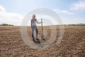 Woman farmer stands on his parched meadow. farmer at drought field.
