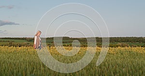 Woman farmer walking through a picturesque field of wheat