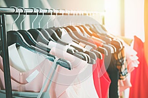 Woman fashion clothes of different colors clothing on hangers at the showroom - Hanging clothes closet rack