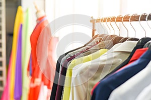 Woman fashion clothes of different colors clothing on hangers at the showroom - Hanging clothes suit colorful or closet rack