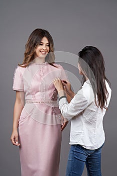 Woman fashion designer measuring dress on fashion model girl