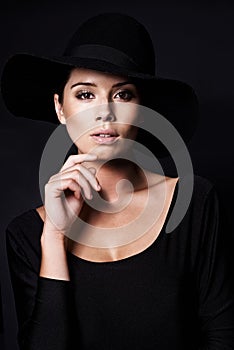 Woman, fashion and hat in portrait with beauty, mob or classic gangster style on black background. Confidence, stylish