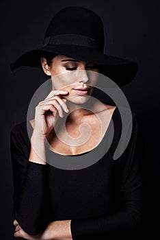 Woman, fashion and hat in studio with beauty, mob or classic gangster style on black background. Confidence, stylish