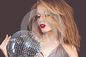 Woman with fashion makeup holding disco ball