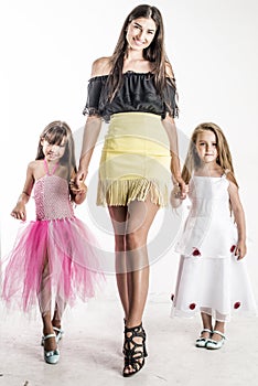 Woman fashion model on the catwalk with two little girls