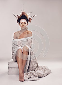 Woman, fashion and native american headdress in studio with feathers in hair, portrait and culture make up in modern