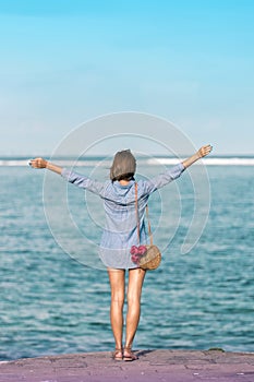 Woman with fashionable stylish rattan bag and silk scarf outside. Tropical island of Bali, Indonesia. Rattan handbag and