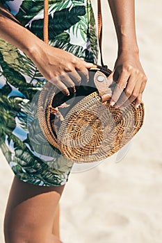 Woman with fashionable stylish rattan bag and silk scarf outside. Tropical island of Bali, Indonesia. Rattan handbag and