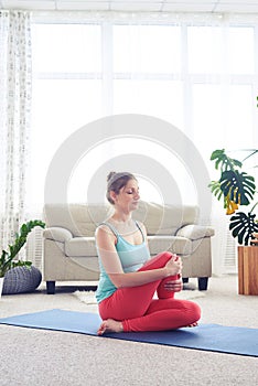 Woman in fashionable tights doing yoga fish pose on yoga mat