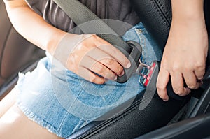 Woman fastening car seatbelt