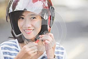 Woman fastening her motorbike helmet