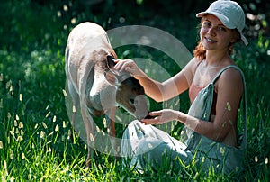 Woman feed bambi deer. Unity with nature. Wild animals concept. Girl feeding fawn. Animal at park.