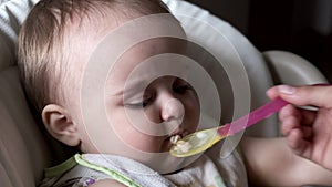 Woman feeding child with spoon.