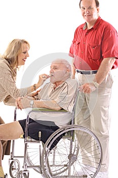 Woman feeding elderly man in wheelchair