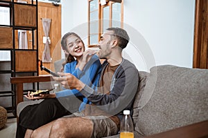 woman feeding her boyfriend a snack sitting on the couch