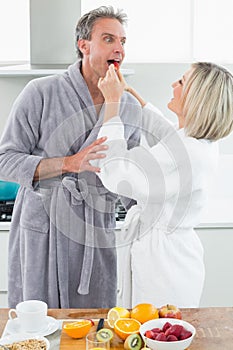 Woman feeding man in the kitchen