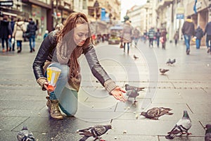 Woman feeds pigeons on the street