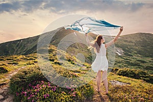 Woman feel freedom and enjoying the mountain nature at sunset
