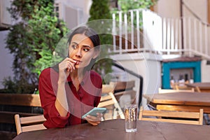 Woman feeling bored while waiting for her order in cafe