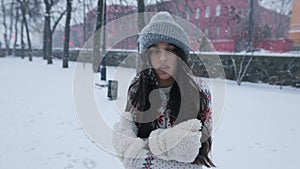 Woman feeling cold in park covered in snow with copy space