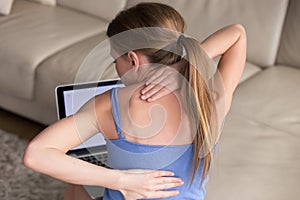 Woman massaging her tense and stiff back muscles photo