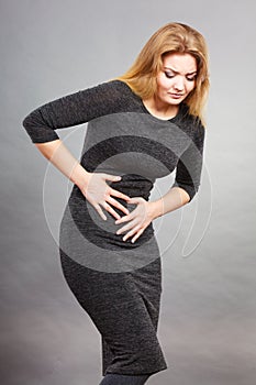 Woman feeling stomach cramps holding her belly