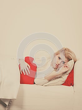 Woman feeling stomach cramps lying on cofa