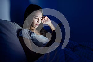 Woman feeling tired with using mobile phone on bed