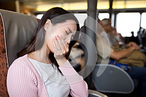 Woman feeling unwell and sitting on the ferry