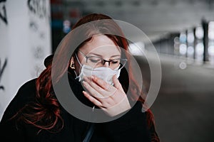 Woman feeling unwell and wearing face mask in city