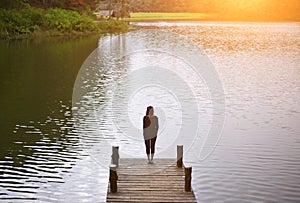 Woman feeling victorious facing on the bridge in the lake