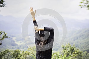 Woman feeling victorious facing on the mountain,