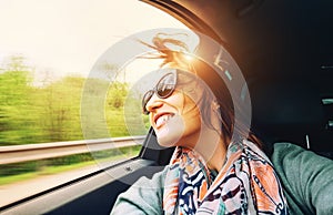 Woman feels free and looks out from open window car