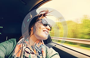 Woman feels free and looks out from open window car