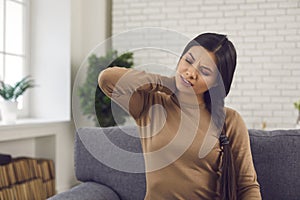 Woman rubbing her neck, suffering from pinched nerve, osteochondrosis or whiplash photo